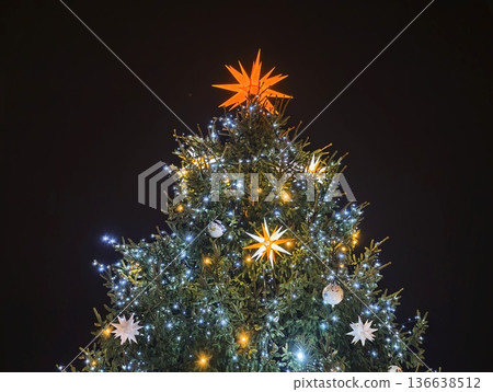 Refined Evergreen Adorned With Radiant Star And Cool White Lighting For Evening Celebration 136638512