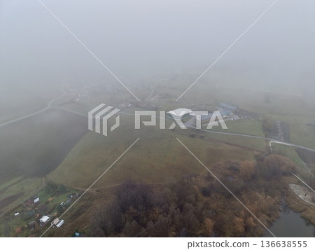 Serene Rural Landscape, Quiet Valley With Foggy Woods, Misty Hillsides And Solitary Structures Evoke Calm Serene Rural Landscape, Quiet Valley With Foggy Woods, Misty Hillsides And Solitary Structures Evoke Calm 136638555