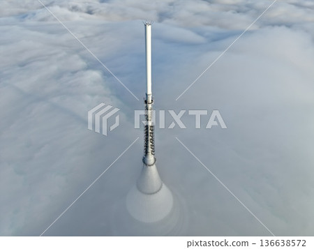 Communication Tower Glows, Rural Broadcasting Station Surrounded By Fog With Distant Mountain Backdrop Communication Tower Glows, Rural Broadcasting Station Surrounded By Fog With Distant Mountain Backdrop 136638572