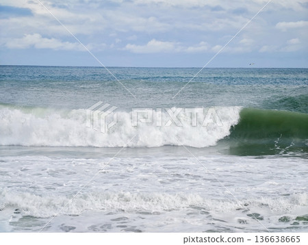 Waves Collide With Sandy Shoreline, Rough Ocean Surf Crashes Onto Deserted Coastlines Creating Dynamic Sprays 136638665