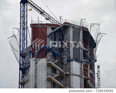 Building Structure With Safety Features, Exterior Stairwell And Protective Netting In Construction 136638680