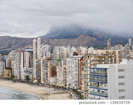 Stormy Cityscape Imagery, Heavy Storm Clouds Cast Shadows Over Densely Built Coastal Neighborhoods 136638739