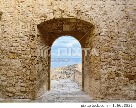 Sunlit Gateway To Seaside Journey, Historic Stone Arch Leading To Scenic Coastal Walking Trail Sunlit Gateway To Seaside Journey, Historic Stone Arch Leading To Scenic Coastal Walking Trail 136638821