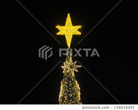 Illuminated Crown On Holiday Pine, Night Scene Showcasing Glowing Star On Decorated Evergreen Tree Illuminated Crown On Holiday Pine, Night Scene Showcasing Glowing Star On Decorated Evergreen Tree 136638885