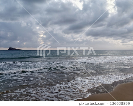 Stormy Sea Scene, Brooding Storm Clouds Cast Shadows Over Churning Sea And Rugged Islet In Distance Stormy Sea Scene, Brooding Storm Clouds Cast Shadows Over Churning Sea And Rugged Islet In Distance 136638899