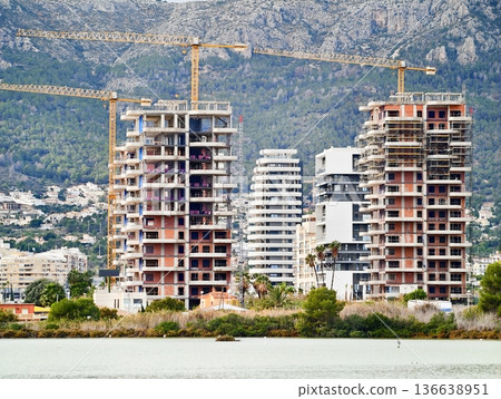 Seaside Building Progress, Modern Coastal Structures Rising Amidst Scenic Mountain And Water Backdrop 136638951