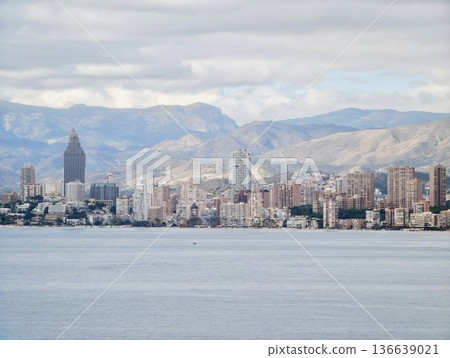 Tranquil Bay Under Cloudy Sky, Peaceful Harbor With Mountain Backdrop And Reflective Waters 136639021