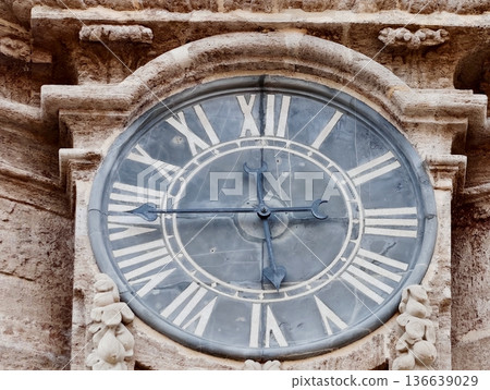 Aged Clock Detailed, Ancient Clock Face Showing Faded Roman Numerals And Decorative Carvings With Cracks 136639029