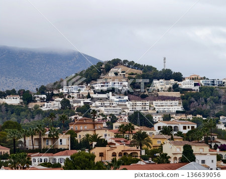 White Stucco Homes Amidst Palms, Serene Hillside Community Featuring Winding Streets And Tiled Balconies White Stucco Homes Amidst Palms, Serene Hillside Community Featuring Winding Streets And Tiled Balconies 136639056