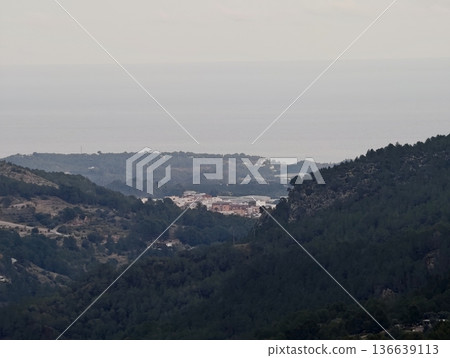 Serene Coastal Landscape Showcasing Rolling Green Hills And Forested Ridges Framing Tranquil Bay 136639113