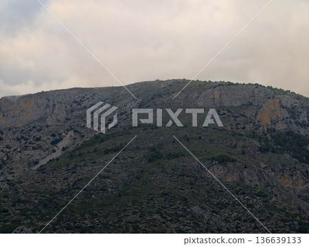 Calm Coastal Hill With Muted Colors, Gentle Elevated Landform Surrounded By Soft Colors And Distant Fog Calm Coastal Hill With Muted Colors, Gentle Elevated Landform Surrounded By Soft Colors And Distant Fog 136639133