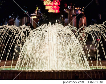 Peaceful City Square Illuminated By Gentle Golden Light With Shimmering Water And Distant Signs 136639181