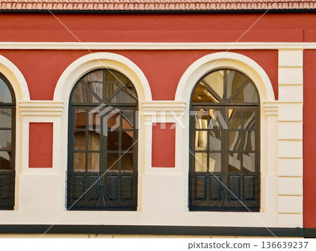 Classic Urban Architectural Features, Red Building With Cream Trim And Arch Windows Reflecting Warm Light Classic Urban Architectural Features, Red Building With Cream Trim And Arch Windows Reflecting Warm Light 136639237