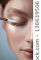 Close up of eyelash lamination process on a woman's eye, beauty magazine editor applying treatment with a brush in a professional setting 136639506