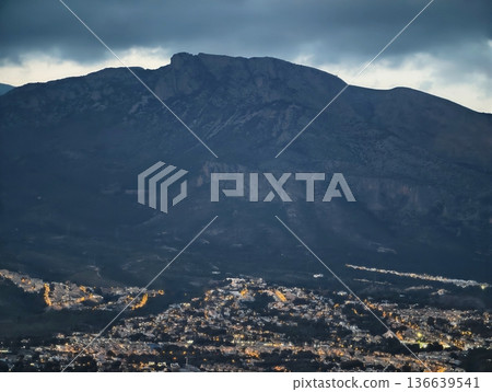 Dusk Cityscape With Distant Lights, Panoramic Scene Of Illuminated City With Surrounding Natural Landscape 136639541