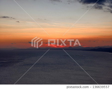 Fiery Horizon With Quiet Ocean Backdrop, Intense Evening Skies Cast Shadows On Tranquil Shoreline Waters Fiery Horizon With Quiet Ocean Backdrop, Intense Evening Skies Cast Shadows On Tranquil Shoreline Waters 136639557