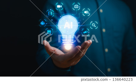 Artificial intelligence innovation concept showing glowing AI light bulb above human hand, symbolizing digital technology, automation, data science, and smart future ideas in business. 136640223