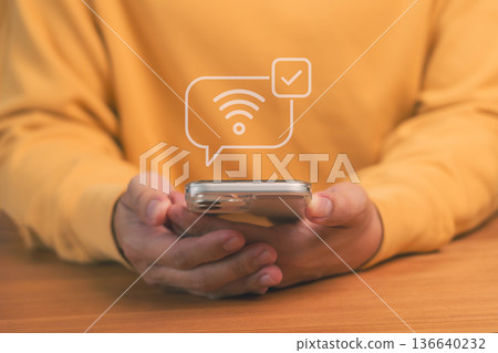 Mobile internet connection concept showing person holding smartphone with wifi signal and check mark icon, symbolizing online access, wireless communication, and digital connectivity technology. 136640232