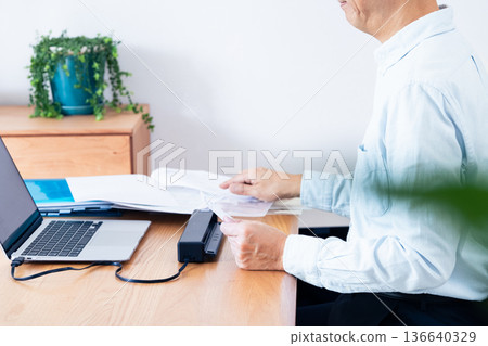一名男子的手正準備提交他的報稅表 136640329