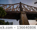 A dramatic upward view of the Queensboro Bridge captured during the evening light. The intricate steel framework and stone pillar highlight the bridge's architectural detail. 136640806
