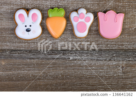 Gingerbread Easter cookies with colorful icing on wooden table. Gingerbread Easter cookies with colorful icing on wooden table. 136641162