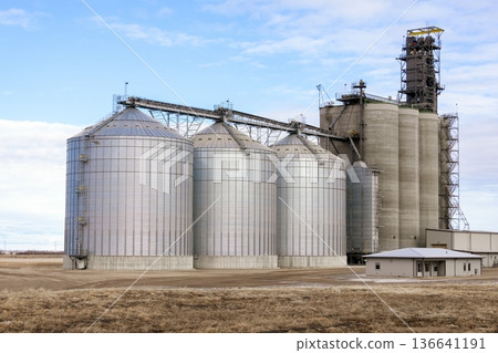 Grain elevator in spring field under clouds in silent prairies. Grain elevator in spring field under clouds in silent prairies. 136641191