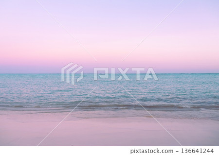 Tropical sunset with pink cloudy sky and peaceful water. Tropical sunset with pink cloudy sky and peaceful water. 136641244