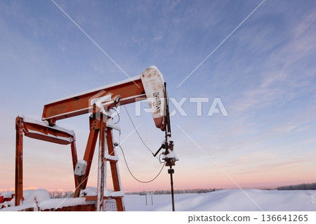 Snow Covered Oil Pumpjack at Winter Sunrise Snow Covered Oil Pumpjack at Winter Sunrise 136641265