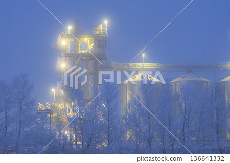 Lights on grain elevator storage in foggy winter night. Lights on grain elevator storage in foggy winter night. 136641332