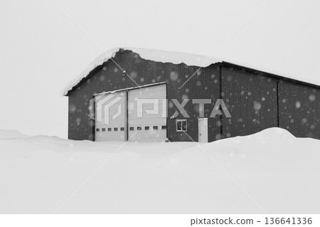 Industrial storage building covered with snow after snowfall. Industrial storage building covered with snow after snowfall. 136641336