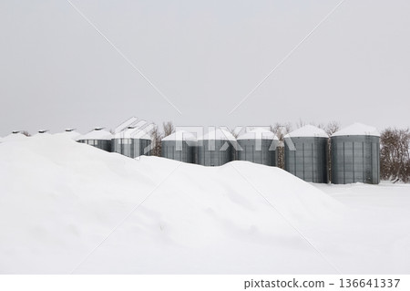 Monochrome of steel grain bins covered with snow after snowfall. Monochrome of steel grain bins covered with snow after snowfall. 136641337