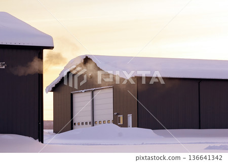 Steam from heater in industrial building in sunset time in winter. Steam from heater in industrial building in sunset time in winter. 136641342