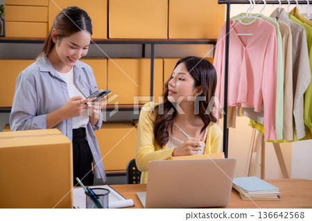 Two asian woman working in small business online store, online seller. Two asian woman working in small business online store, online seller. 136642568
