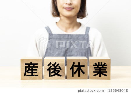一位身穿圍裙、手持寫著「產假」字樣牌子的女士 一位身穿圍裙、手持寫著「產假」字樣牌子的女士 136643048