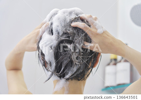 Woman washing her hair in the bathroom, back view Woman washing her hair in the bathroom, back view 136643501