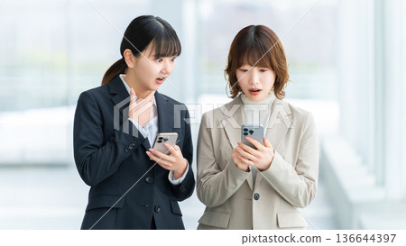 兩位女性/女商人對她們的智慧型手機感到驚訝 136644397