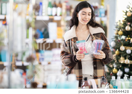Young woman choosing razor in decorated store 136644428