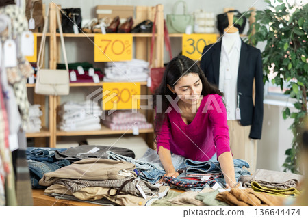 Young woman choosing shorts and pants in the store Young woman choosing shorts and pants in the store 136644474