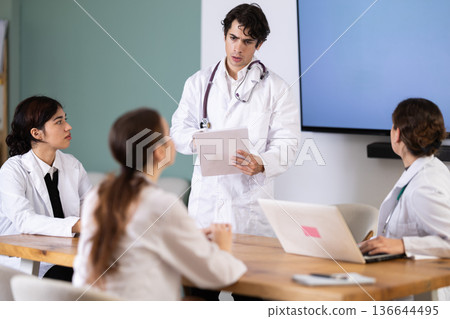 Young male doctor leading medical meeting in office 136644495