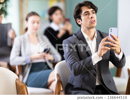 Man on corporate training scans a qr code on mobile Man on corporate training scans a qr code on mobile 136644519