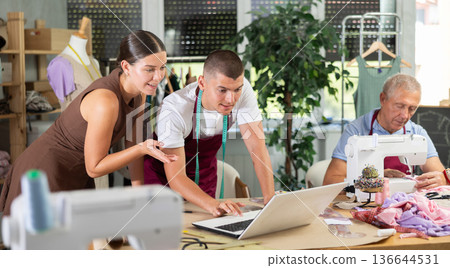 woman with a team of tailors designing clothes in a workshop 136644531