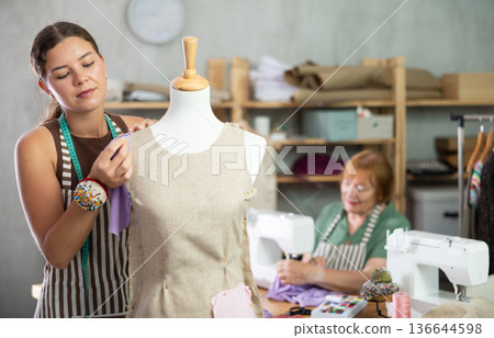 Woman working with mannequin against the background of an elderly dressmaker 136644598