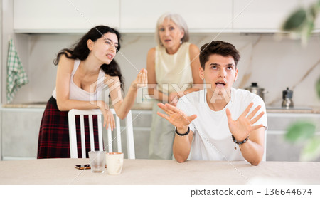 Elderly woman mother and young girl during family quarrel accuse adult son Elderly woman mother and young girl during family quarrel accuse adult son 136644674