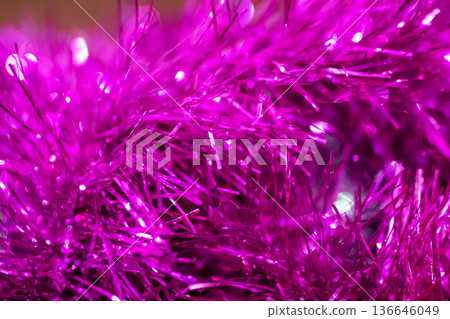 Bright magenta tinsel with shimmering metallic strands enhances festive settings 136646049