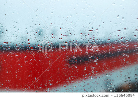Raindrops on window with city view. City station scene with raindrops and soft lights reflected 136646094