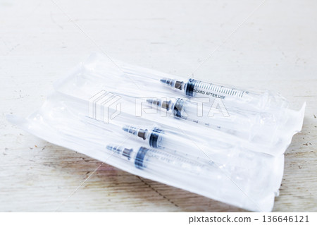 Clean medical scene with arranged disposable syringes prepared for patient vaccination Clean medical scene with arranged disposable syringes prepared for patient vaccination 136646121