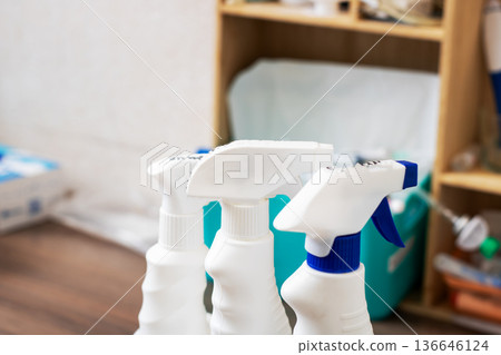 Meticulously arranged cleaning products including sprays and labeled containers visible 136646124