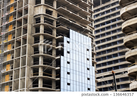Concrete tower under development. Industrial building featuring scaffolding and raw surfaces Concrete tower under development. Industrial building featuring scaffolding and raw surfaces 136646357