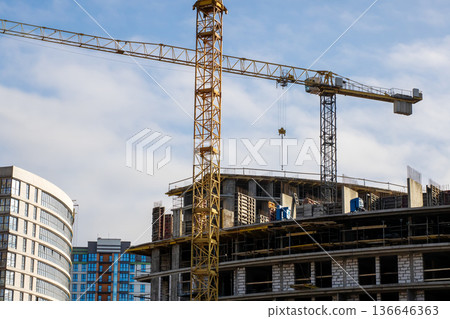 Highrise development with crane lifting precast elements amidst urban surroundings Highrise development with crane lifting precast elements amidst urban surroundings 136646363