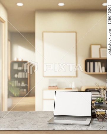 White screen laptop and coffee on marble counter table across frame and bookshelf in a living room. 136646865